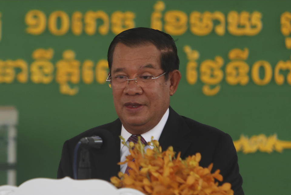 Cambodian Prime Minister Hun Sen smiles as his delivers a speech during a handover ceremony at Phnom Penh International Airport, in Phnom Penh, Cambodia, Sunday, Feb. 7, 2021. Cambodia on Sunday received its first shipment of COVID-19 vaccine, a donation of 600,000 doses from China, the country's biggest ally. Beijing has been making such donations to several Southeast Asian and African nations in what has been dubbed "vaccine diplomacy," aimed especially at poorer countries like Cambodia. (AP Photo/Heng Sinith)