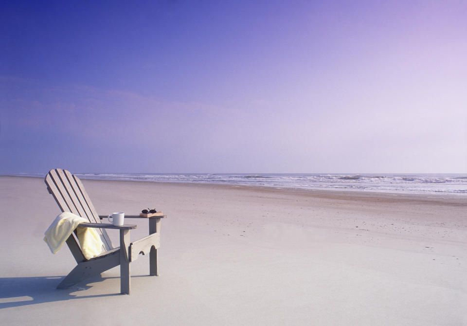 Photo of a beautiful sandy beach with a white lounge chair