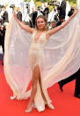 En une seule tenue, Kimberley Garner a rassemblé toutes les tendances "Cannes 2019" ! Une cape XXL pour jouer avec ses pans, une décolleté en V plongeant, une robe fendue et du glitter… De manière surprenante, ce riche mélange fonctionne sur la silhouette de la créatrice anglaise de swimwear.