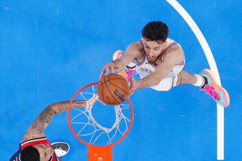 Thunder forward Chet Holmgren dunks beside Wizards forward Kyle Kuzma during Friday's game at Paycom Center.