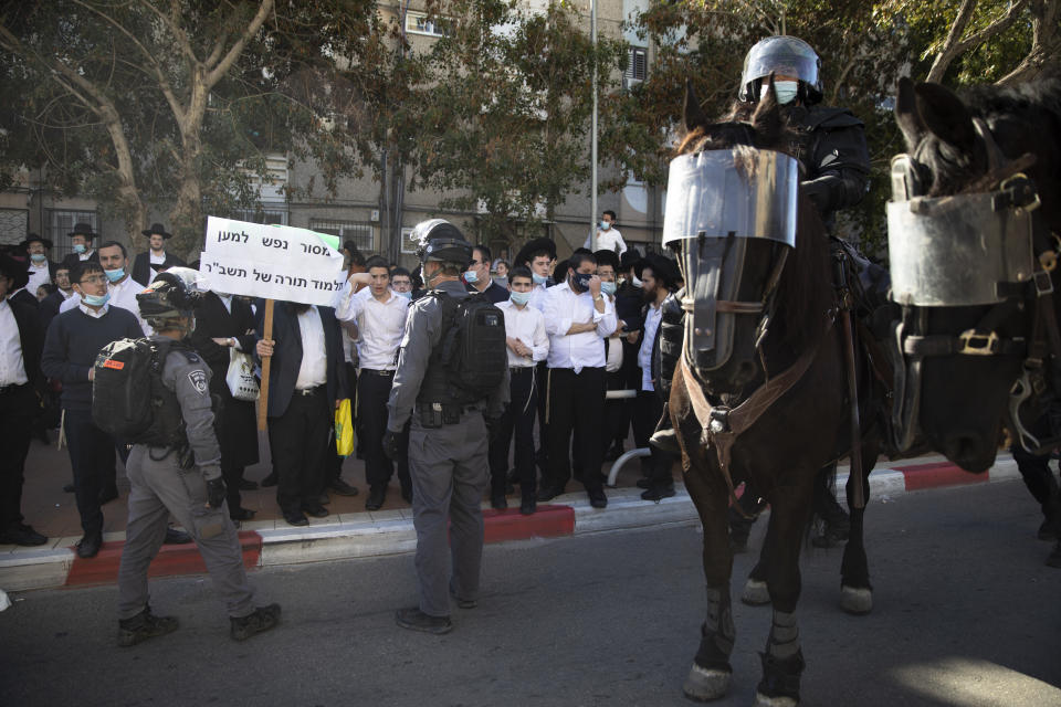 Israeli police officers clash with ultra-Orthodox Jews in Ashdod, Israel, Sunday, Jan. 24, 2021. Ultra-Orthodox demonstrators clashed with Israeli police officers dispatched to close schools in Jerusalem and Ashdod that had opened in violation of coronavirus lockdown rules, on Sunday. (AP Photo/Oded Balilty)