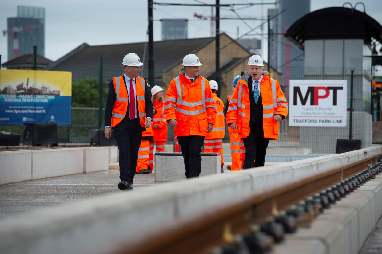 Britain's Prime Minister Boris Johnson walks with CEO of Transport for the North, Barry White and Britain's Northern Powerhouse Minister, Jake Berry as he visits the site of an under-construction tramline in Stretford, near Manchester, Britain July 27, 2019. Geoff Pugh/Pool via REUTERS