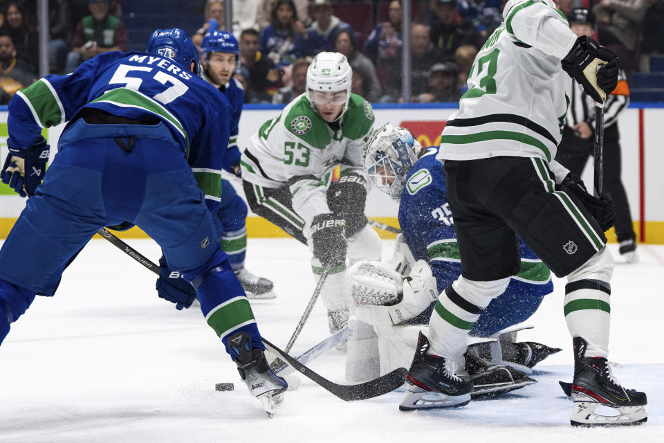 Vancouver Canucks goaltender Thatcher Demko (35) stops Dallas Stars' Wyatt Johnston (53) as Canucks' Tyler Myers (57) watches during the first period of an NHL hockey game Saturday, Nov. 4, 2023, in Vancouver, British Columbia. (Ethan Cairns/The Canadian Press via AP)