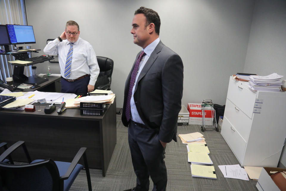 In this Tuesday, Oct. 29, 2019, photo, attorney Adam Slater, right, meets with his firm's managing attorney, Steven Alter, left, in Melville, N.Y. Slater said since New York state opened its one-year window allowing sex abuse suits with no statute of limitations, his firm has signed up nearly 300 new clients, prompting new hires of paralegals to field calls. (AP Photo/Bebeto Matthews)