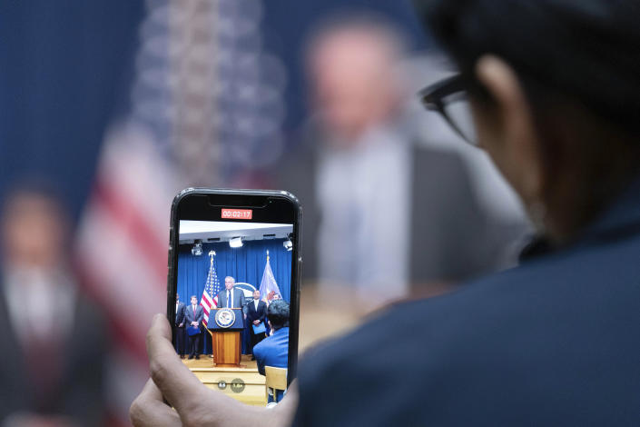 Assistant Secretary for Export Enforcement Matthew Axelrod of the U.S. Commerce Department, is seen on cell phone as he speaks during a news conference at the Department of Justice in Washington, Tuesday, May 16, 2023. (AP Photo/Jose Luis Magana)