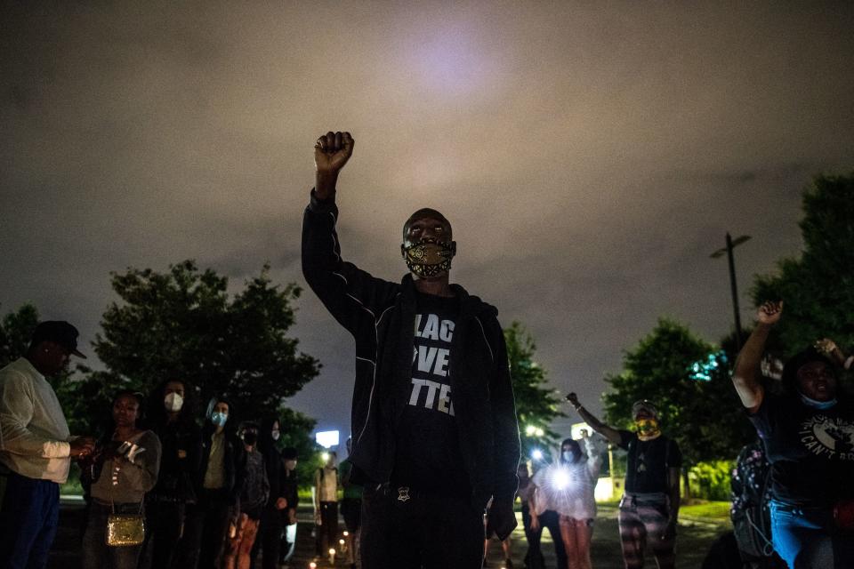 A protester raises his hand as he protests outside a burned Wendy's restaurant on the third day following Rayshard Brooks shooting death by police in the restaurant parking lot in Atlanta, Georgia, June 15, 2020. (Chandan Khanna/AFP via Getty Images)