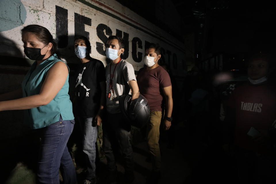 People line up outside a polling station after closing time to vote during general elections in Tegucigalpa, Honduras, Sunday, Nov. 28, 2021. The National Electoral Council announced that polling stations that still had people waiting outside to vote should stay open until all had a chance to cast their ballots. (AP Photo/Moises Castillo)