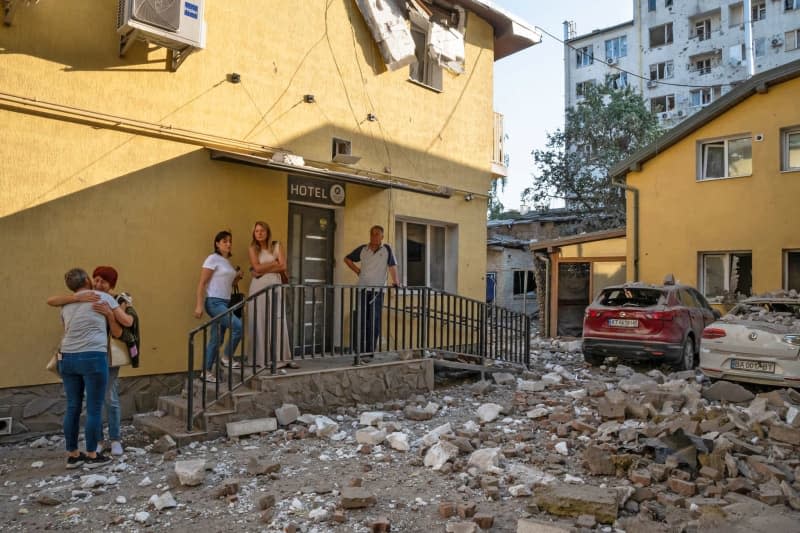 People stay outside a hotel in the Zaliznychnyi district after the Russian missile attack on Lviv, western Ukraine. Seven people were killed, including two children, and 53 people were injured. -/Ukrinform/dpa