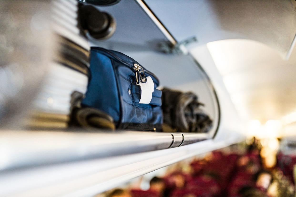 Close up of hand-luggage compartment with suitcases in airplane