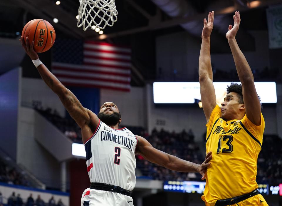 Connecticut  guard R.J. Cole drives to the basket against Marquette forward Oso Ighodaro in the first half.