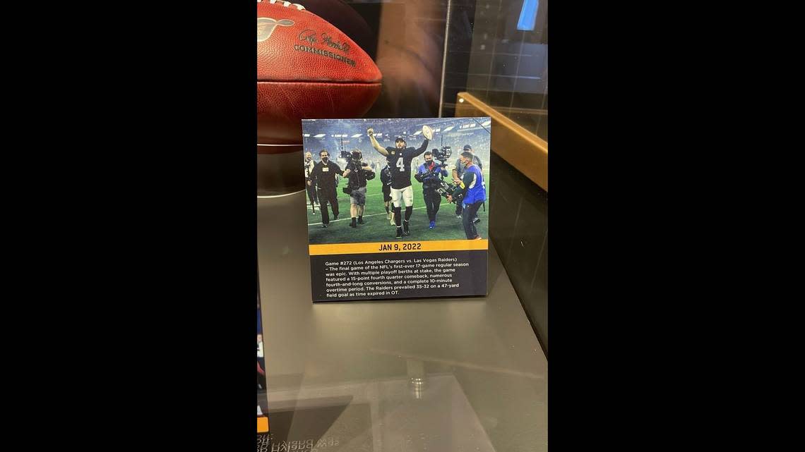 Las Vegas Raiders quarterback Derek Carr looks at the card that was placed at the Pro Football Hall of Fame museum that shows the Raiders defeating the Los Angeles Chargers to clinch a playoff berth.