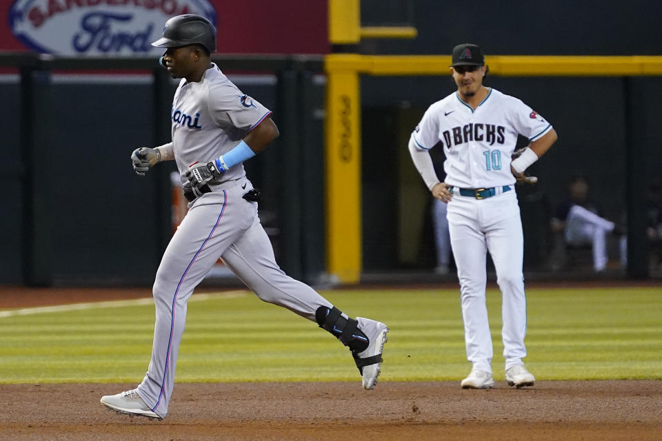 Miami Marlins' Jesus Sanchez rounds the bases after hitting a three run home run as Arizona Diamondbacks' Josh Rojas (10) looks on during the fourth inning of a baseball game, Wednesday, May 10, 2023, in Phoenix. (AP Photo/Matt York)