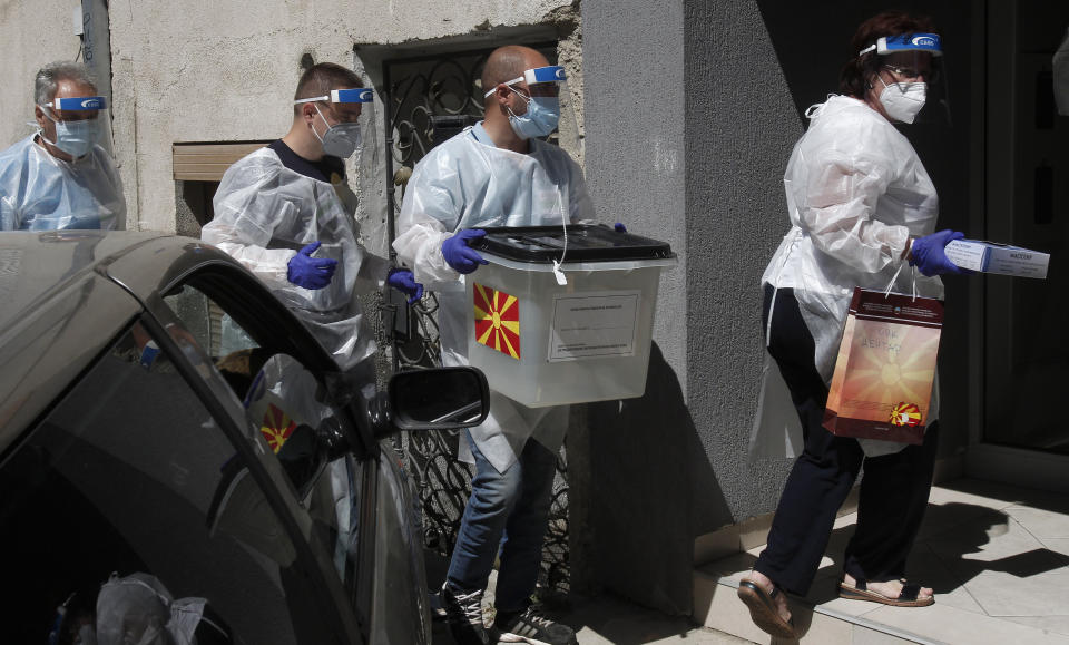 Members of a special election team with a ballot box and voting material make their way to visit voters who have tested positive for COVID-19 or are in self-isolation, in Skopje, North Macedonia on Monday, July 13, 2020. North Macedonia holds its first parliamentary election under its new country name this week, with voters heading to the polls during an alarming spike of coronavirus cases in the small Balkan nation. Opinion polls in the run-up to Wednesday’s vote indicate a close race between coalitions led by the Social Democrats and the center-right opposition VMRO-DPMNE party. (AP Photo/Boris Grdanoski)