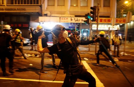 Anti-extradition demonstrators throw rocks, after a march to call for democratic reforms in Hong Kong