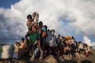 <p>Thousands of Rohingya refugees fleeing from Myanmar walk along a muddy rice field after crossing the border in Palang Khali, Cox’s Bazar, Bangladesh, on October 9, 2017. Well over a half a million Rohingya refugees have fled into Bangladesh since late August during the outbreak of violence in Rakhine state causing a humanitarian crisis in the region with continued challenges for aid agencies. (Photograph by Paula Bronstein/Getty Images) </p>