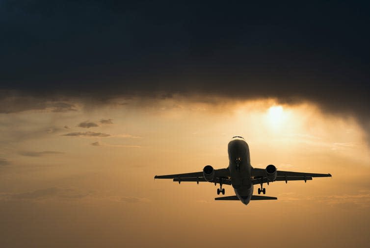 Large plane takes off at sunset