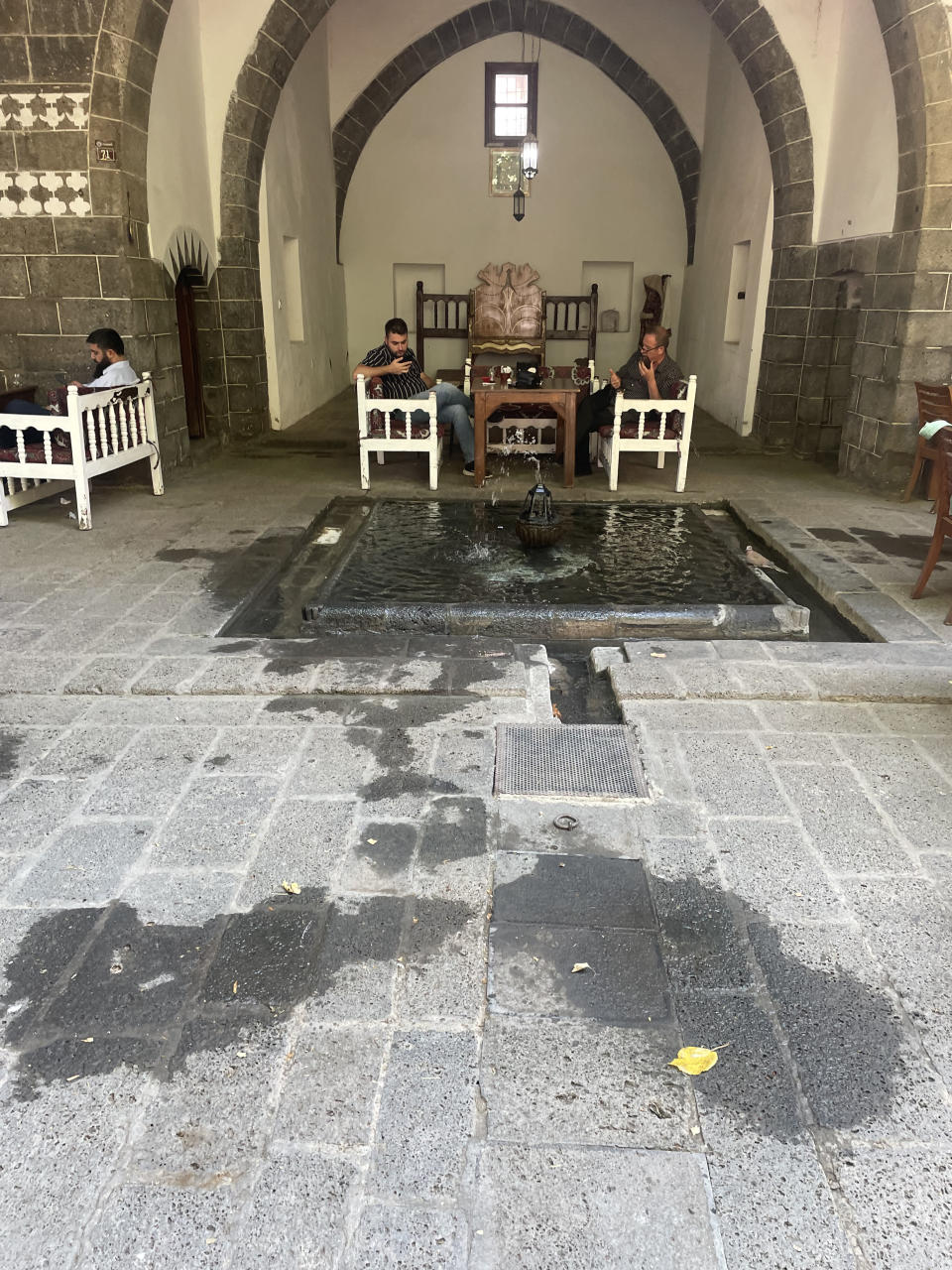 A cafe in Diyarbakır, Turkey. The deeply shaded "iwan" has its back to the sun, and opens to the cooler north side of the courtyard. A fountain and pool at the opening of the iwan creates evaporative cooling. (Philip Kennicott/The Washington Post)