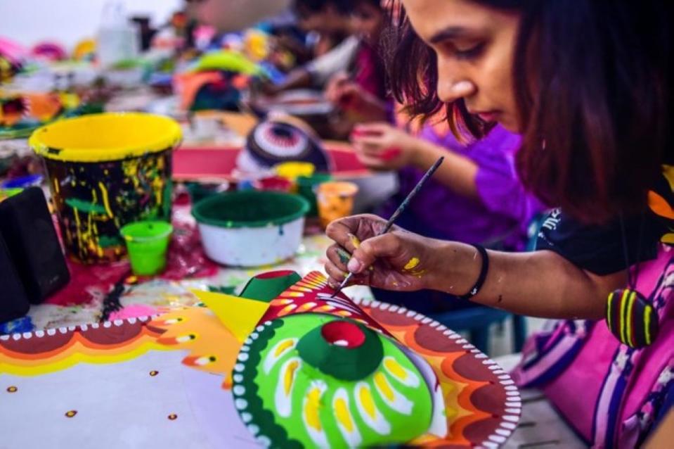 A Bangladeshi student of Dhaka University Art Institute paints a mask to sell as a part of Bengali New Year preparations in Dhaka on April 7, 2019. — AFP pic