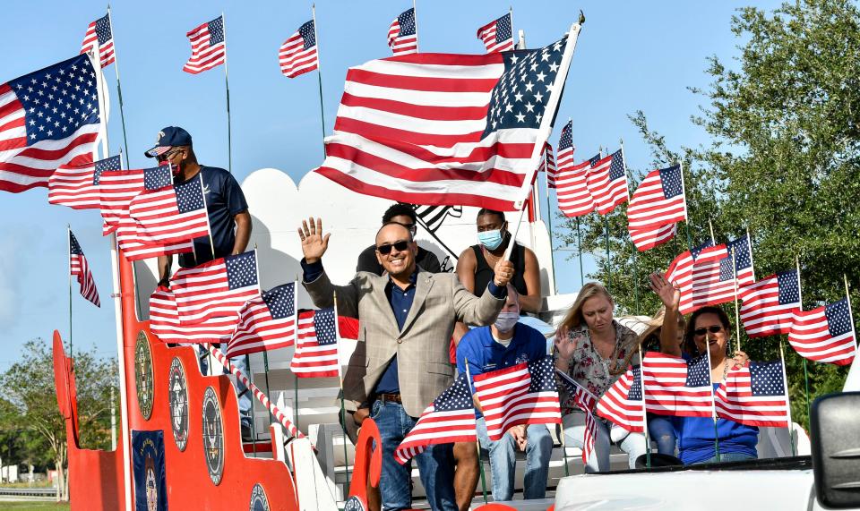 Palm Bay Mayor-Elect Rob Medina waves amid a sea of U.S. flags during the city's 2020 Veterans Parade.