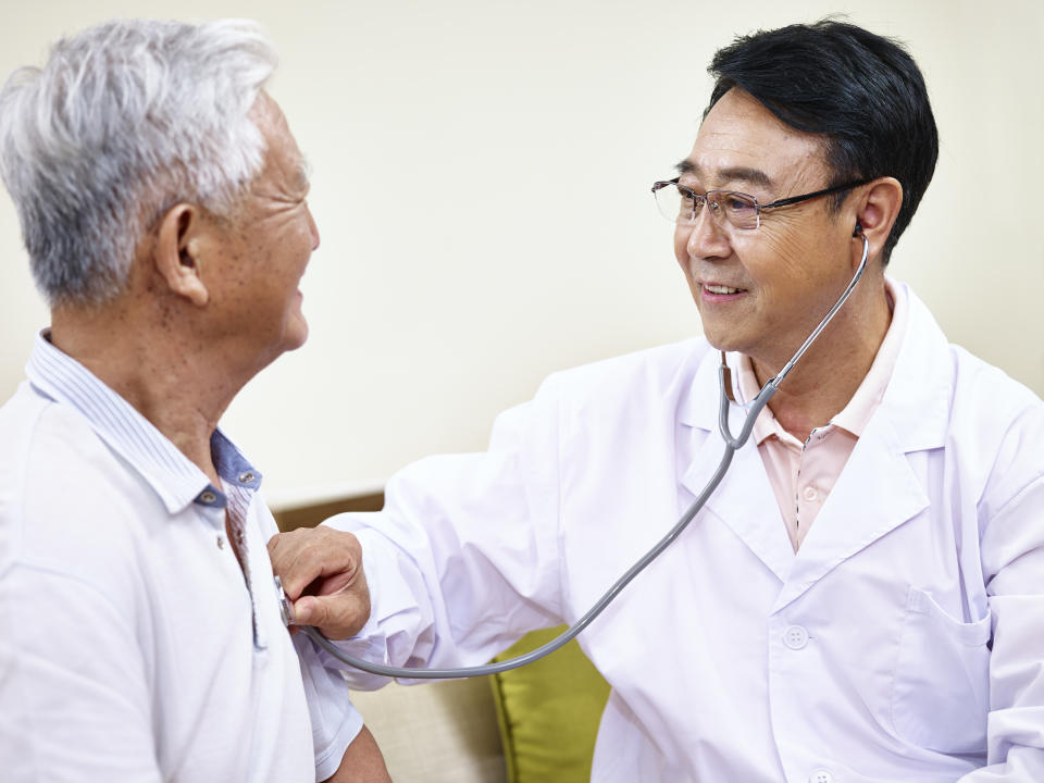 asian doctor checking senior patient using a stethoscope.