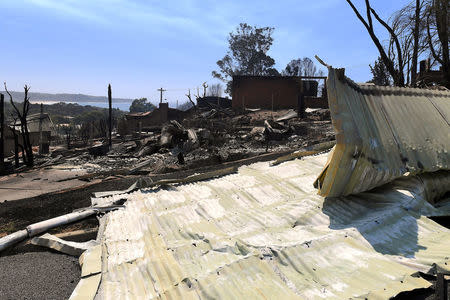 Destroyed homes can be seen after a bushfire swept through the town of Tathra, located on the south-east coast of New South Wales in Australia, March 19, 2018. AAP/Dean Lewins/via REUTERS