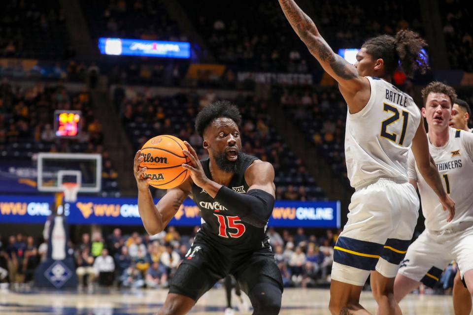 Jan 31, 2024; Morgantown, West Virginia, USA; Cincinnati Bearcats forward John Newman III (15) makes a move against West Virginia Mountaineers guard RaeQuan Battle (21) during the first half at WVU Coliseum.