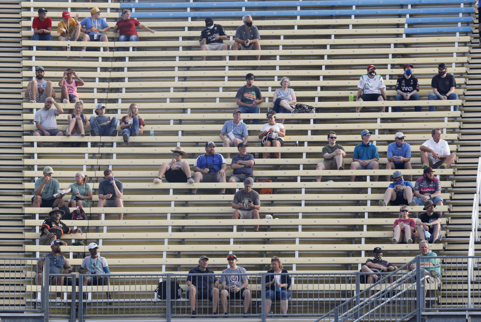 Fans sit in spread out groups as they watch the IndyCar Series auto race Friday, July 17, 2020, at Iowa Speedway in Newton, Iowa. (AP Photo/Charlie Neibergall)