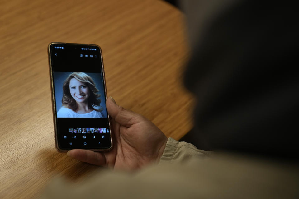 Cigdem Kuzey, shows a photograph of her late sister, Muhterem Evcil, during an interview with the Associated Press in Istanbul, Turkey, Wednesday, March 6, 2024. Muhterem Evcil was stabbed to death by her estranged husband at her workplace in Istanbul, where he had repeatedly harassed her in breach of a restraining order. More than a decade later, her sister believes Evcil would still be alive if authorities had enforced laws on protecting women and jailed him. (AP Photo/Khalil Hamra)