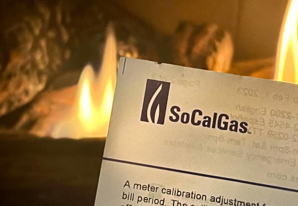 A gas fireplace illuminates a SoCalGas bill. 

