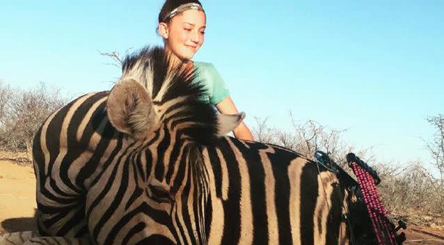 Aryanna also posted this image with a zebra she had hunted and killed with father Eli. Source: Facebook/BraidsandBows