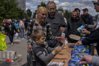 People queue to receive food donations in Kharkiv, eastern Ukraine, Thursday, May 19, 2022. (AP Photo/Bernat Armangue)