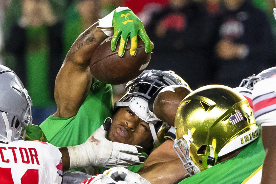 Notre Dame running back Gi'Bran Payne reaches over the Ohio State defensive line for a touchdown as his helmet comes off during the second half of an NCAA college football game Saturday, Sept. 23, 2023, in South Bend, Ind. (AP Photo/Michael Caterina)