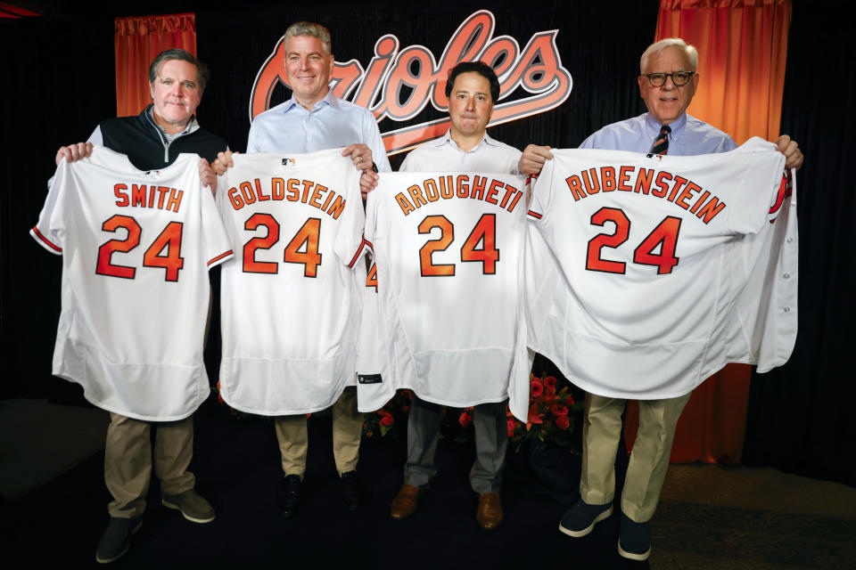 Baltimore Orioles majority owner David Rubenstein, right, poses for photos with members of the ownership group, Michael Smith, Mitchell Goldstein and Michael Arougheti at a press conference prior to a baseball game against the Los Angeles Angels, Thursday, March 28, 2024, in Baltimore. (AP Photo/Julia Nikhinson)