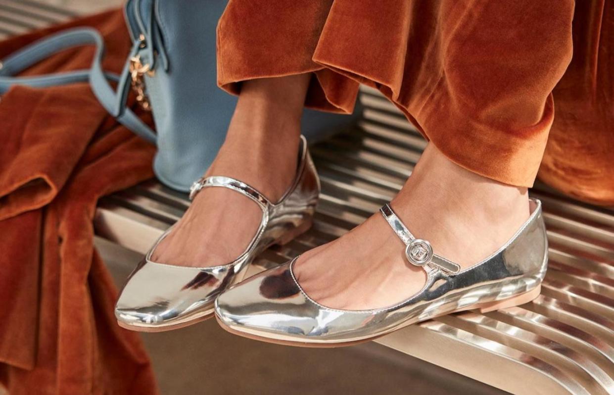 model wearing shiny silver mary jane flats