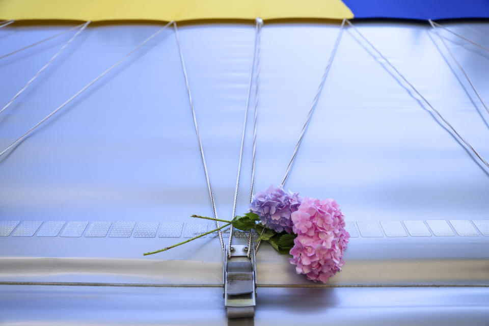 A flower is seen in Visoko, Bosnia, Sunday, July 9, 2023 on a truck carrying 30 coffins with remains of the recently identified victims of the 1995 Srebrenica genocide. So far, the remains of more than 6,600 people have been found and buried at a vast and ever-expanding memorial cemetery in Potocari, outside Srebrenica. (AP Photo/Armin Durgut)