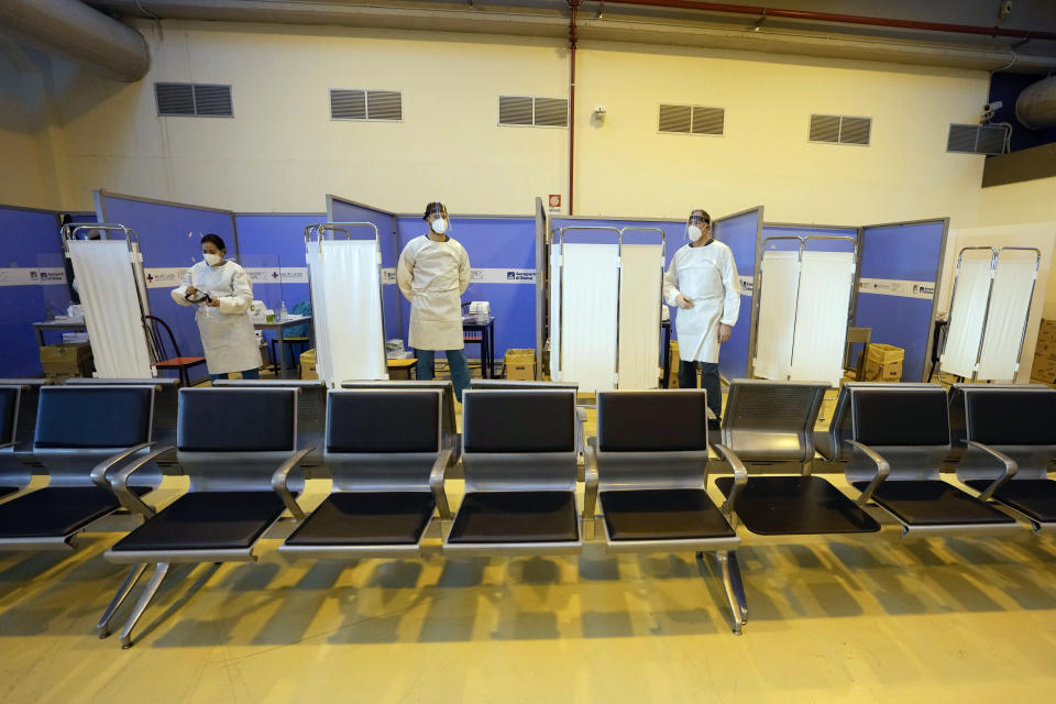 FILE - Medical personnel wait for passengers coming with an Air China flight from Guangzhou, China, in a COVID-19 testing area set at Rome's Leonardo da Vinci international airport in Fiumicino, Thursday, Dec. 29, 2022 after Italy made coronavirus tests mandatory for all airline passengers arriving from China. European Union nations are fine-tuning a coordinated response to China's COVID-19 crisis on Wednesday, Jan. 4, 2023 and are zeroing in on travel restrictions that would upset both Beijing and the global airline industry. (AP Photo/Alessandra Tarantino, File)