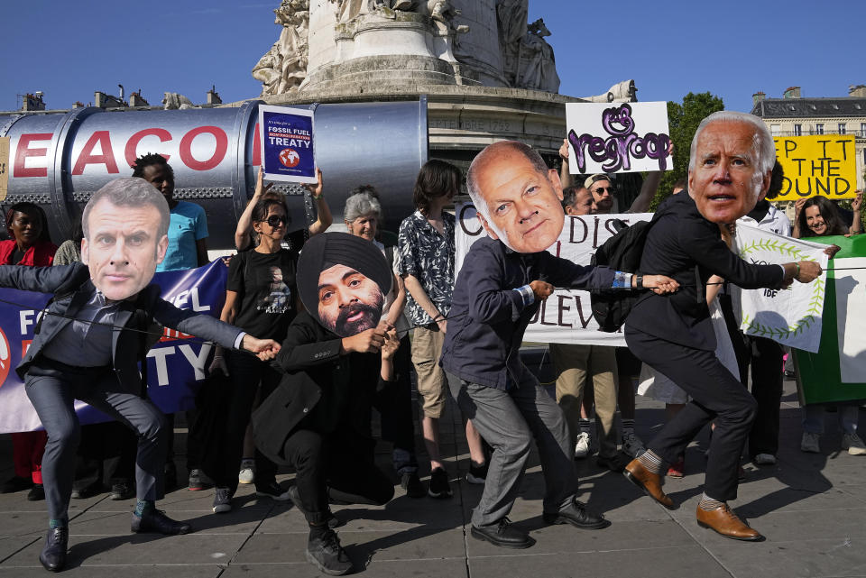 Climate activists wearing the masks of world leaders, from left; French President, Emmanuel Macron, World Bank President Ajay Banga, German Chancellor, Olaf Scholz and US President, Joe Biden, stage a protest in the Place de la Republique on the sidelines of the Global Climate Finance Summit in Paris, Friday, June 23, 2023. World leaders, heads of international organizations and activists are gathering in Paris for a two-day summit aimed at seeking better responses to tackle poverty and climate change issues by reshaping the global financial system. (AP Photo/Michel Euler)