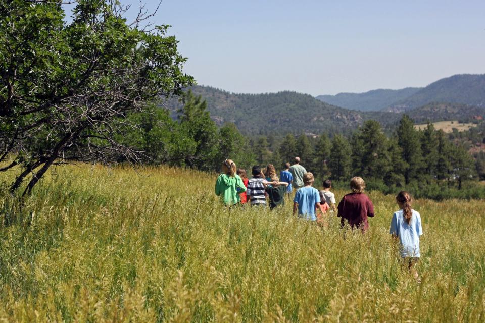 Nature and Wildlife Discovery Center program participants hike through a meadow in Pueblo Mountain Park.