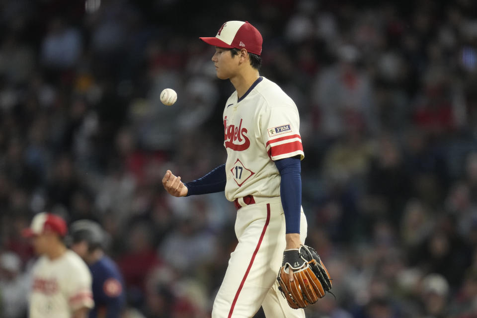 Los Angeles Angels starting pitcher Shohei Ohtani (17) tosses a ball on the mound during the fifth inning of a baseball game against the Houston Astros in Anaheim, Calif., Tuesday, May 9, 2023. (AP Photo/Ashley Landis)