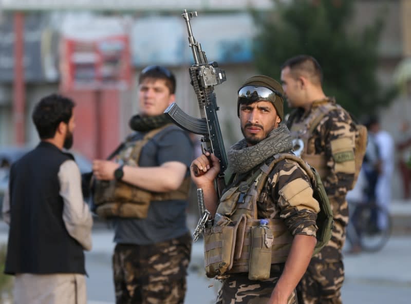 Afghan security forces keep watch at the side of bomb blast in Kabul