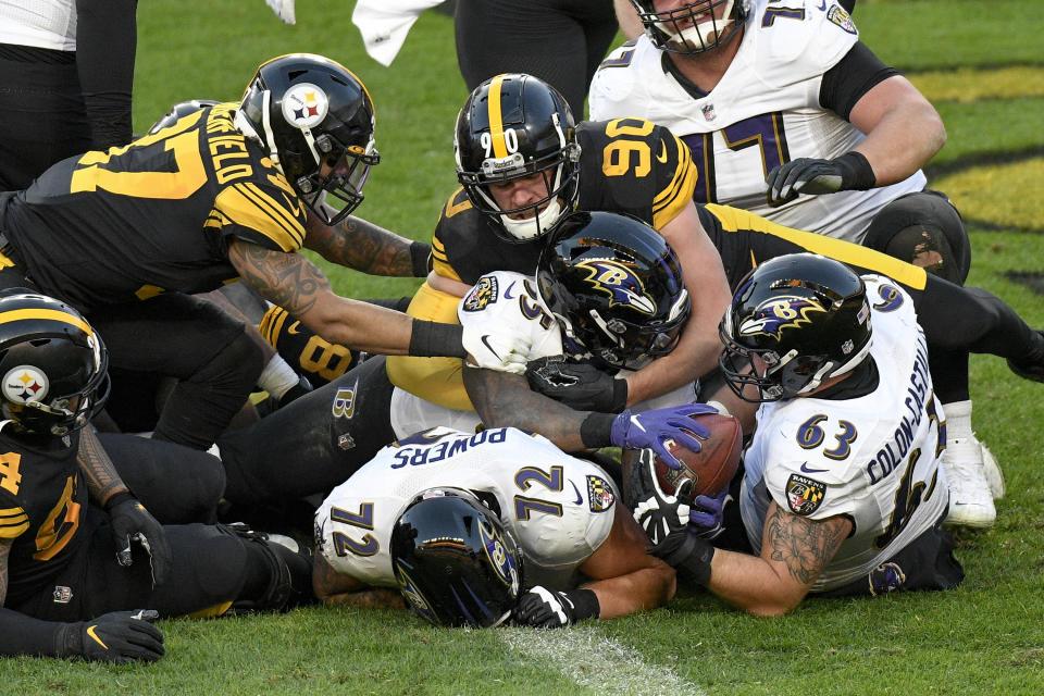 Baltimore Ravens running back Gus Edwards (35) gets into the end zone with a touchdown under Pittsburgh Steelers outside linebacker T.J. Watt (90) during the first half of an NFL football game, Wednesday, Dec. 2, 2020, in Pittsburgh. (AP Photo/Don Wright)