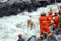 <p>Rescue workers pull a rescue dog across a river at the site of a landslide in the village of Xinmo, Mao County, Sichuan Province, China June 25, 2017. (Photo: CNS/An Yuan via Reuters) </p>