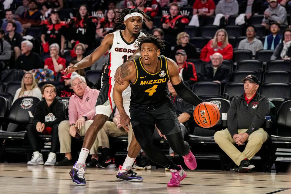 Missouri Tigers guard DeAndre Gholston (4) dribbles past Georgia Bulldogs guard Mardrez McBride (13) during the first half at Stegeman Coliseum in Athens, Georgia.