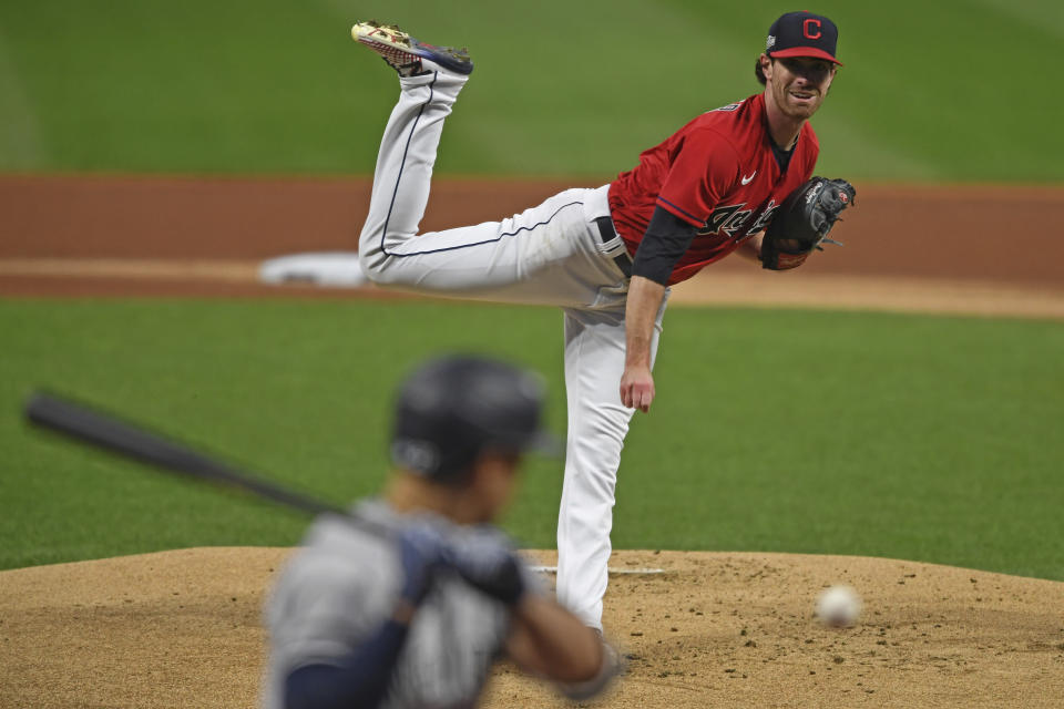 Cleveland Indians starting pitcher Shane Bieber (57) delivers to New York Yankees' Giancarlo Stanton (27) in the first inning of Game 1 of an American League wild-card baseball series, Tuesday, Sept. 29, 2020, in Cleveland. (AP Photo/David Dermer)