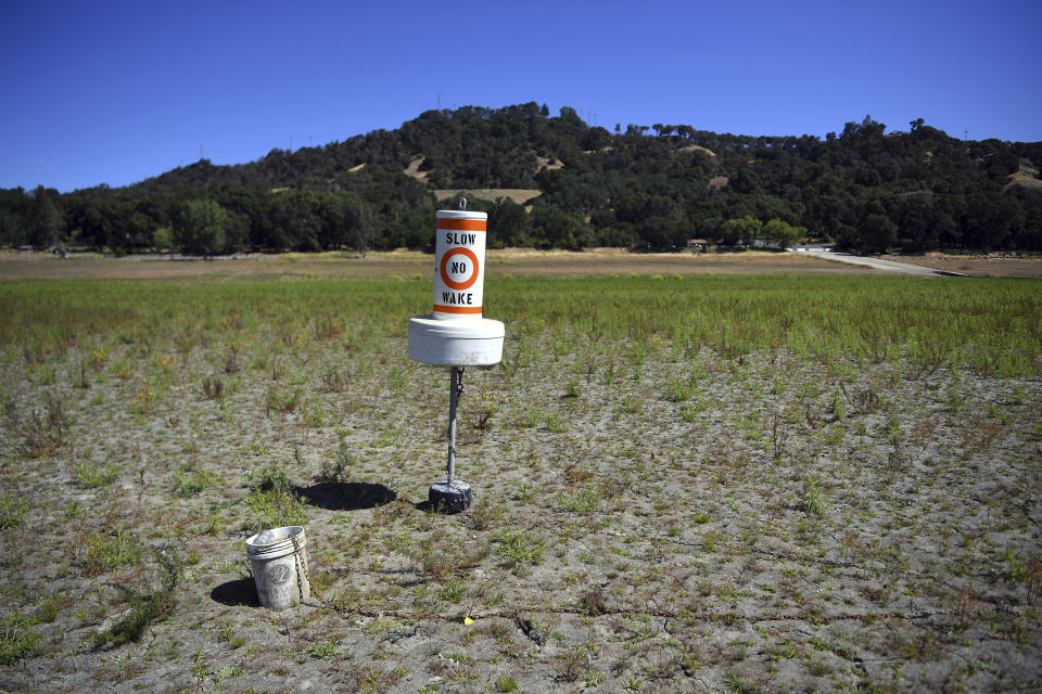 A buoy sits on dry land that had been under water, at a drought-stricken Lake Mendocino, currently at 29% of it normal capacity, in Ukiah, Calif., on Sunday, May 23, 2021. California Gov. Gavin Newsom declared a drought emergency for most of the state. (AP Photo/Josh Edelson)