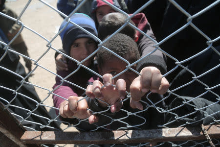 Children look through a chain linked fence at al-Hol displacement camp in Hasaka governorate, Syria March 8, 2019. REUTERS/Issam Abdallah