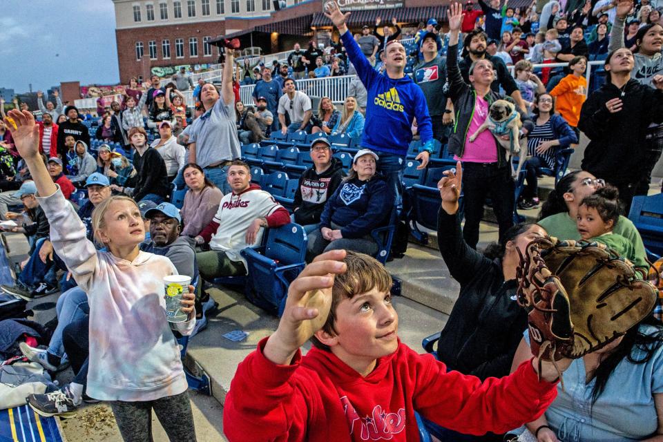 Fans look to catch a fly ball during the Wilmington Blue Rocks South Atlantic League home opener against the Hickory Crawdads at Frawley Stadium in Wilmington, Tuesday, April 11, 2023. Hickory won 3-2.