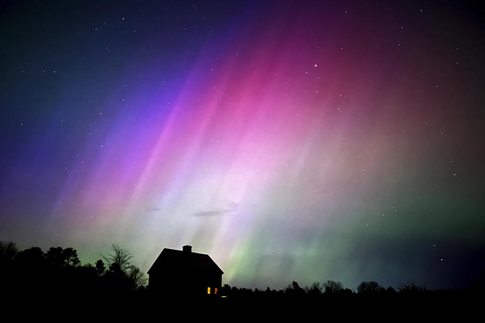 The Northern Lights shine in the sky over a farmhouse on the evening of Friday, May 10, 2024, in Brunswick, Maine.  / Credit: Robert F. Bukaty / AP