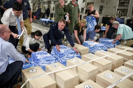 Crew and officials from the United Nations Command and U.S. Defense POW/MIA Accounting Agency (DPAA) secure UNC flags over transit cases of remains thought to be of U.S. soldiers killed in the 1950-53 Korean War, before returning them to the United States for further processing and identification, in Wonsan, North Korea, July 27, 2018. Courtesy U.S. Forces Korea/Handout via REUTERS