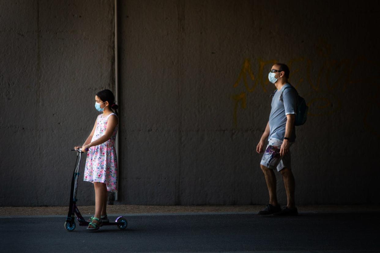 <span class="caption">Keeping kids safe is complicated and requires care for both physical and mental health.</span> <span class="attribution"><a class="link " href="https://www.gettyimages.com/detail/news-photo/little-girl-wearing-a-protective-face-mask-rides-an-news-photo/1226986917" rel="nofollow noopener" target="_blank" data-ylk="slk:Pablo Cuadra/Getty Images;elm:context_link;itc:0;sec:content-canvas">Pablo Cuadra/Getty Images</a></span>